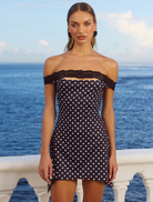 Black polka dot mini dress with a fitted silhouette and short sleeves, perfect for casual or semi-formal occasions.