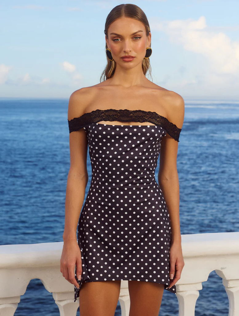 Black polka dot mini dress with a fitted silhouette and short sleeves, perfect for casual or semi-formal occasions.
