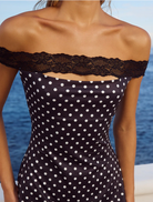 Elegant black mini dress adorned with polka dots, designed with short sleeves and a tailored fit for a chic look.